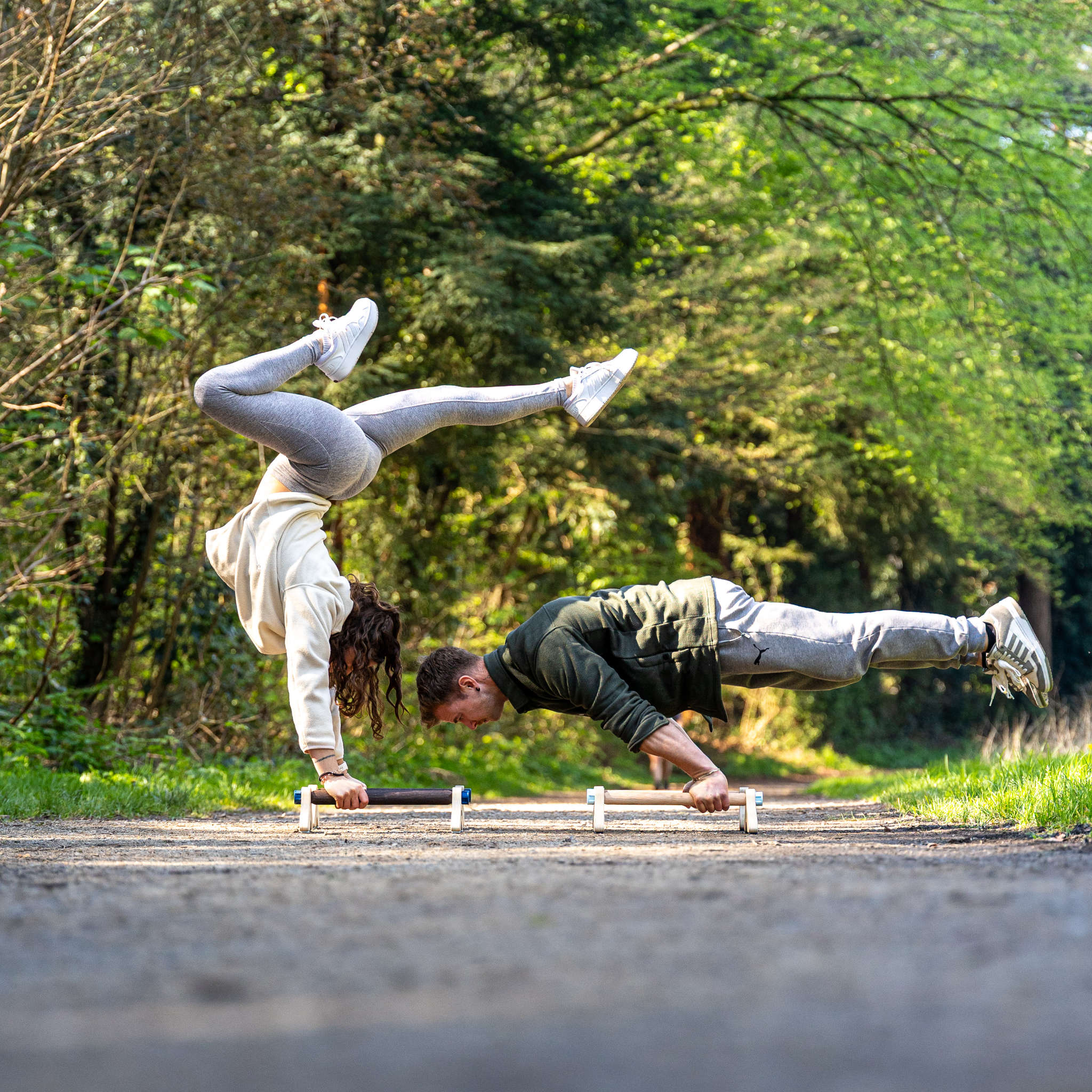 photo de deux personnes réalisant un handstand et une full planche dans la nature sur des parallettes Peisma