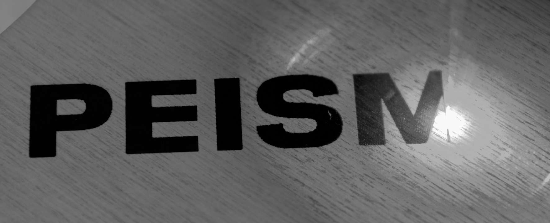 Image d'une gravure d'un produit Peisma sur du bois.