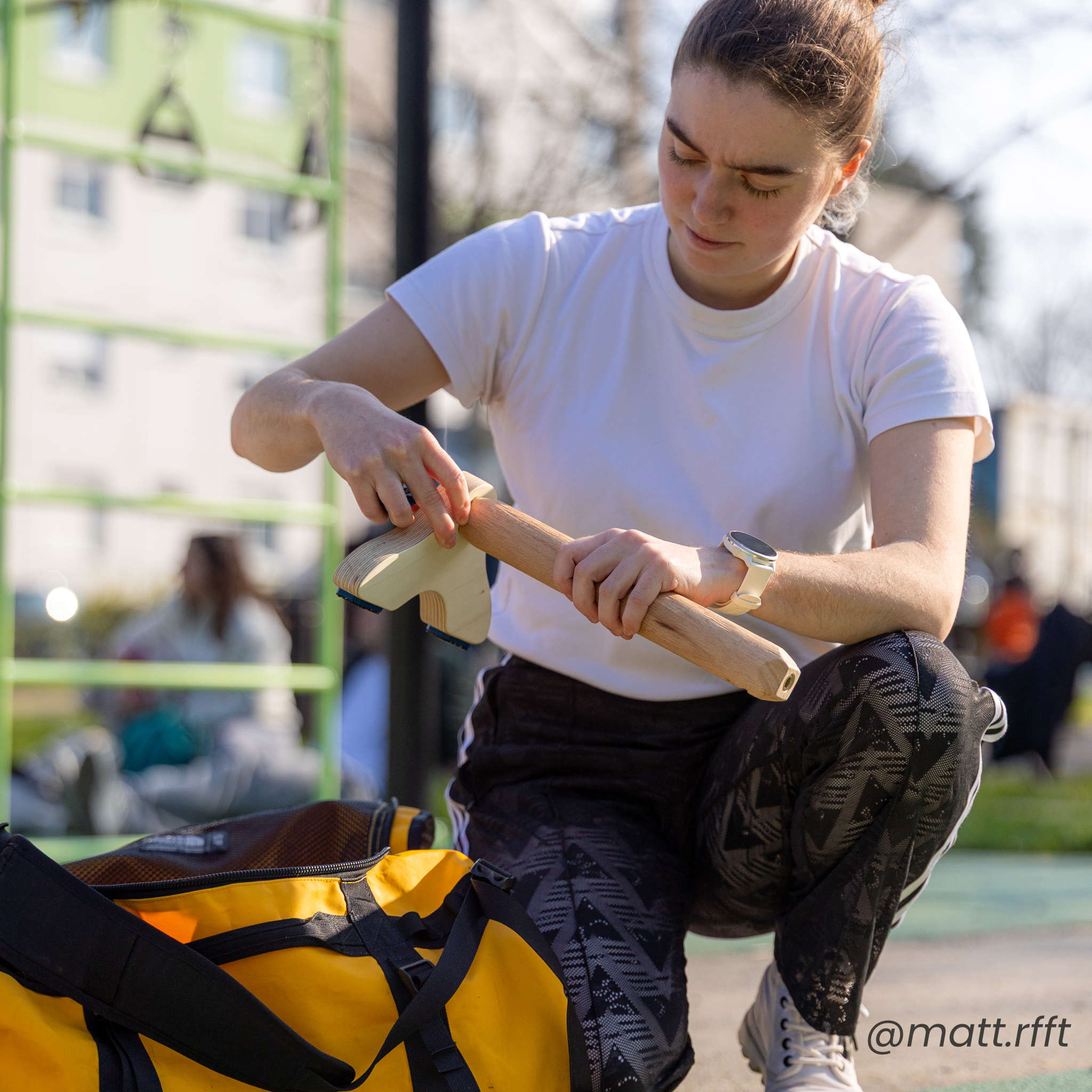 photo d'une personne en train de visser un socle d'une parallette Peisma sur un parc de street workout et callisthénie