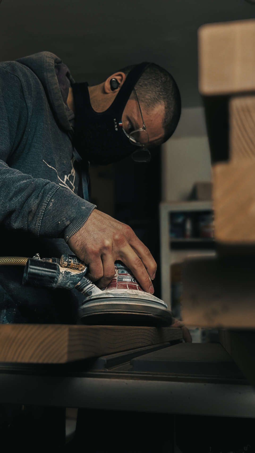 Photo d'un artisan de Peisma en train de poncer une planche en bois.
