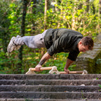 personne faisant une full planche sur des parallettes Peisma en haut d'un escalier dans la nature